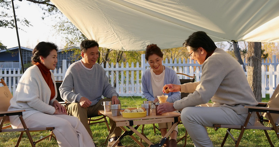 一群中老年人露营地天幕下喝咖啡聊天视频