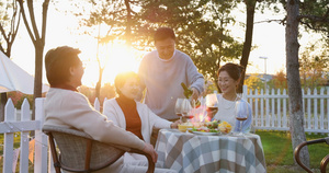 夕阳下中老年朋友在庭院里聚会喝酒聊天28秒视频