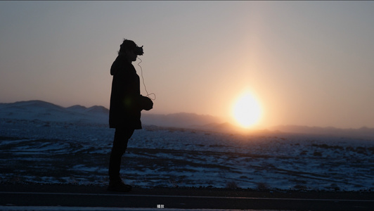 4K新疆一个人站在夕阳雪地上操作穿越机[人围]视频