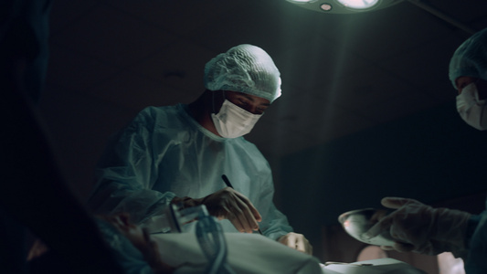 外科医生在黑暗的急诊病房里操作手术视频