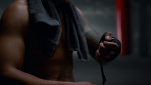 肌肉男性在手上拉绷带包裹手部准备拳击训练17秒视频