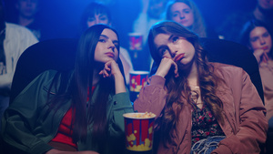 年轻女孩们在电影院感到无聊打哈欠22秒视频