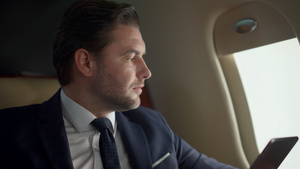 在飞机窗口特写男性白领使用平板电脑工作11秒视频