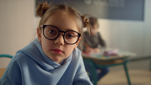戴着眼镜可爱小女孩在学校严肃的面对镜头16秒视频