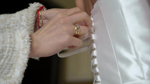 帮助年轻新娘穿上结婚礼服的伴娘奢华的婚纱10秒视频