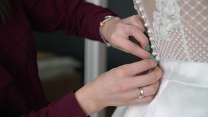 帮助年轻新娘穿上结婚礼服的伴娘12秒视频