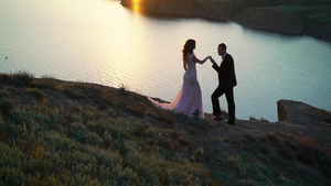 日落时在山上行走的新娘和新郎10秒视频