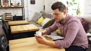顾客在喝咖啡时用他的电话同时喝咖啡11秒视频