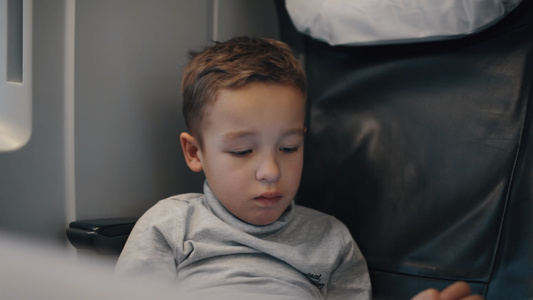 男孩使用平板电脑Pc试图在无聊的火车旅途中娱乐自己视频