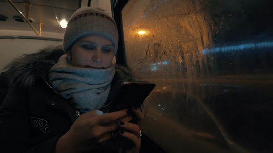 在夜间城市乘公共汽车旅行时使用囚室的妇女视频