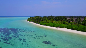 无人空中飞行的豪华海岸海滩风景由清蓝环礁湖和白沙背景16秒视频