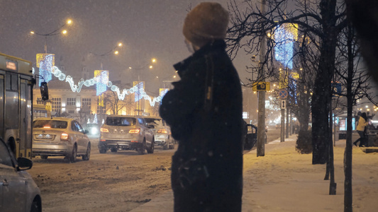 冬天下雪的夜晚在路边等待公交车的乘客视频