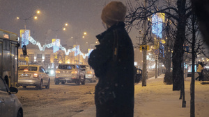 冬天下雪的夜晚在路边等待公交车的乘客16秒视频