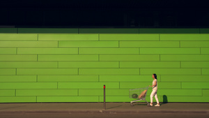 沿绿墙行走的妇女14秒视频