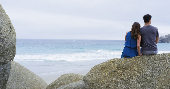 南非开普敦沙滩上坐在巨石上的情侣视频