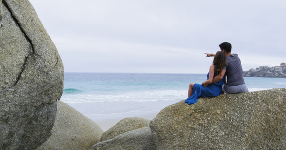 南非开普敦沙滩上坐在巨石上的情侣视频