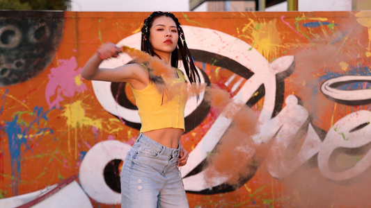 4K潮流嘻哈女孩涂鸦墙下挥动烟雾棒劲舞视频