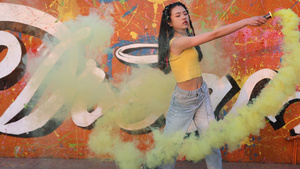 4K潮流嘻哈女孩涂鸦墙下挥动烟雾棒劲舞10秒视频
