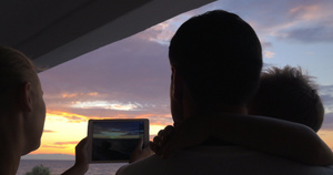 一家人举着ipad拍日落15秒视频