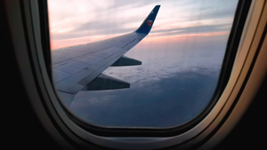 4K旅行途中搭乘飞机透过窗户看天空中晚霞31秒视频