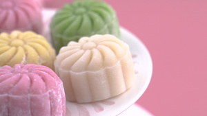 彩色雪皮月饼甜雪月饼中秋节传统咸味甜点淡粉色背景特写25秒视频