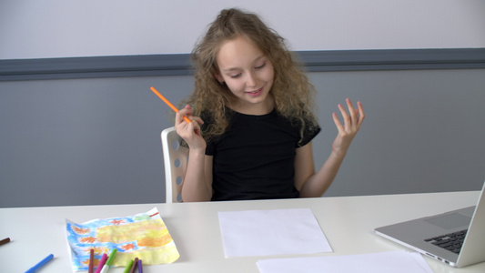 创意女孩用铅笔在桌子上的纸上画画十几岁的女孩在家庭视频