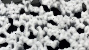 抽象的白色泡沫气泡滑下黑色玻璃洗车香波清洗16秒视频