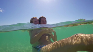 两个可爱的少女在热带沙滩暑假上亲吻和拥抱Gopro30秒视频