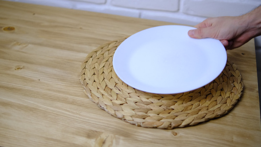 将两个盘子一个勺子和叉子放在木制桌子上一个布条地毯视频