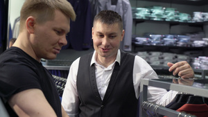购物和时装概念青年男子在商场选择和试穿夹克9秒视频