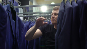 购物和时装概念青年男子在商场选择和试穿夹克7秒视频
