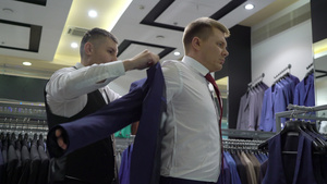 购物和时装概念青年男子在商场选择和试穿夹克18秒视频