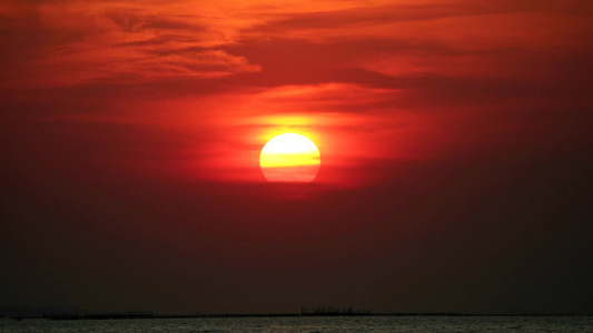 日落在黑暗的天空和红橙色的乌云中阳光照耀着大海视频