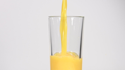 将橙汁倒在白玻璃上视频
