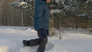 白人男孩走在雪上漂流的冬季公园露天露天20秒视频