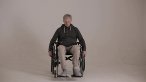 一个灰色头发的男人坐在轮椅上脸色是白色背景的邪恶表情20秒视频