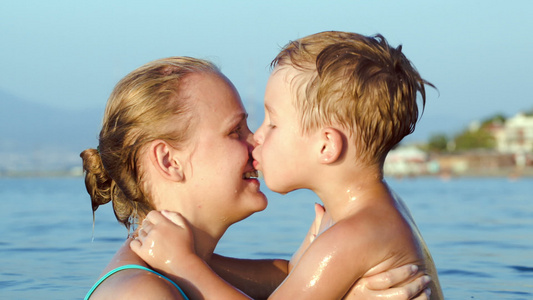 男孩在海中亲吻和拥抱母亲视频