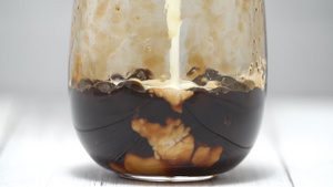 泡茶将混合牛奶和茶倒入白色木桌背景上的红糖图案饮用47秒视频