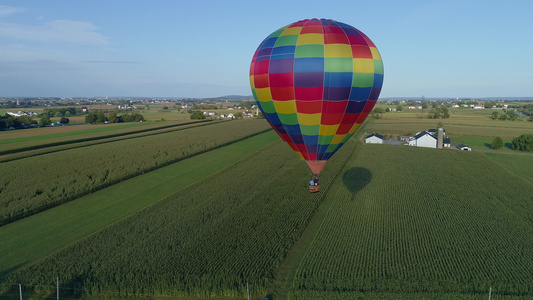 在乡村阳光明媚的夏日节庆典期间农庄上浮的热空气气球视频