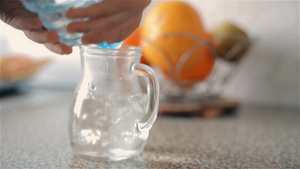 儿童从塑料瓶里倒进一壶干净的饮用水中15秒视频