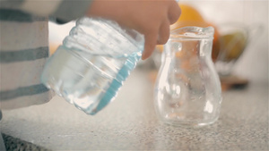 男孩把水从塑料瓶倒进玻璃杯13秒视频