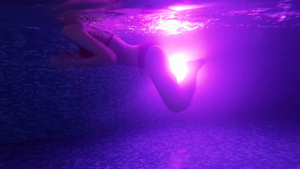 在黑暗泳池里游着适合女性游泳的黑泳池由灯光向后反光23秒视频