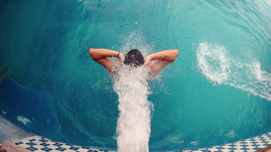 男子在瀑布喷气式飞机下的温泉游泳池中放松视频