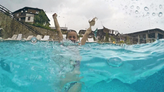 在雨天的游泳池里玩得开心的女孩视频