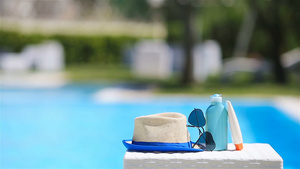 在游泳池附近的太阳镜防晒霜帽子和墨镜15秒视频