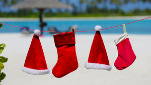 热带海滩上挂着红色圣塔帽和圣诞长袜11秒视频