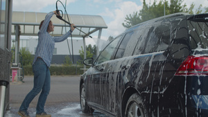30岁的年轻妇女在自助洗车时洗家用汽车女性洗车时外面30秒视频