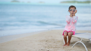 快乐的小女孩手里拿着玩具飞机在白色的沙滩上孩子在沙滩15秒视频