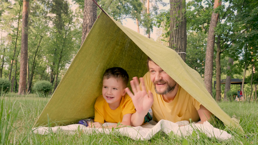 父亲带着儿子躺在营地帐篷里视频