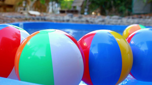 漂浮在游泳池中的彩色海滩球26秒视频